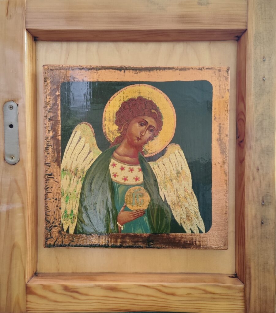 Zdjęcie jednej z ikon prezentowanych na wystawie. Wizrunek anioła w złotej aureoli ze złotymi skrzydłami na zielonym tle.