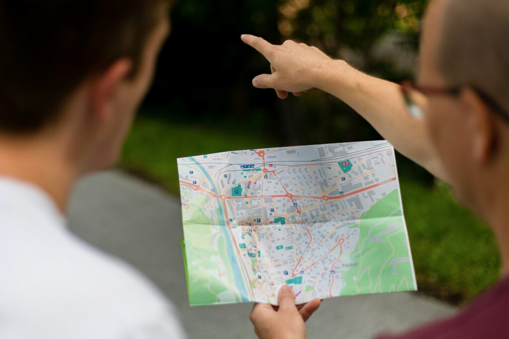 W centrum zdjęcia mapa miasta, widoczna pokazująca w przód męska ręka.