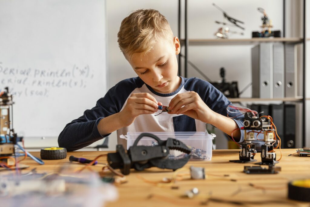 Zdjęcie chłopca budującego robota z klocków
