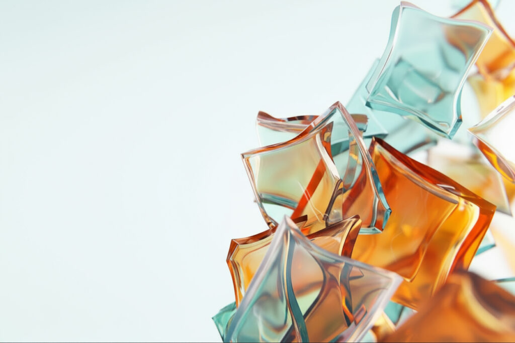 Na jasnym tle nachodzące na siebie, przejrzyste, niewielkie szkiełka w różnych barwach i kształtach.