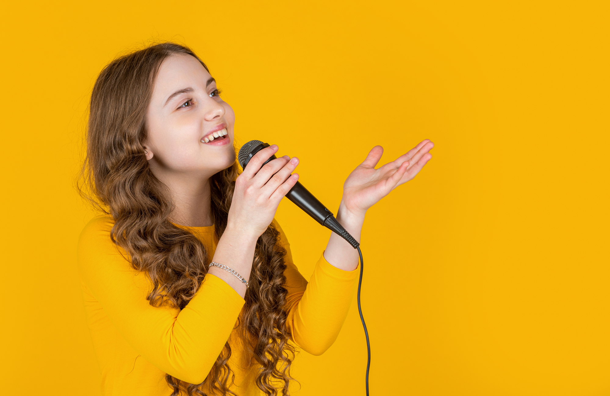 Na żółtym tle dziewczynka z mikrofonem, wykonująca utwór. Ma długie jasne kręcone włosy, ubrana jest na żółto, w lewej ręce trzyma mikrofon.